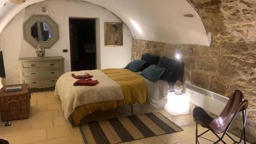 Schlafzimmer mit einem Bett, einer Kommode und einem Spiegel in der Unterkunft la villageoise, chambre troglodyte pitoresque au cœur du village in Rognes