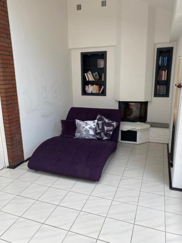 a bedroom with a purple bed on a tiled floor at Apartments Benser-Hof in Bensersiel