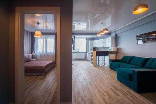 ein Wohnzimmer mit einer grünen Couch und einer Küche in der Unterkunft Apartel Marina in Mamaia Nord – Năvodari