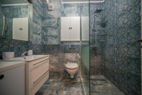 ein Badezimmer mit Toilette und Glasdusche in der Unterkunft Apartel Marina in Mamaia Nord – Năvodari