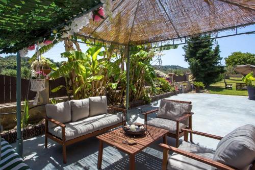 patio z 2 krzesłami, stołem i parasolem w obiekcie Laylande House w mieście Theologos
