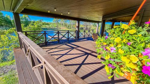 a deck with flowers and a view of the water at Holiday House "Brūklenes" in Talsi