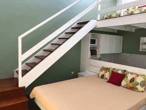 1 dormitorio con 1 cama bajo una escalera en LA COLLINE DU LAGON en Le François