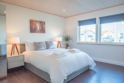 a white bedroom with a bed and a window at Stargaze in Great Yarmouth