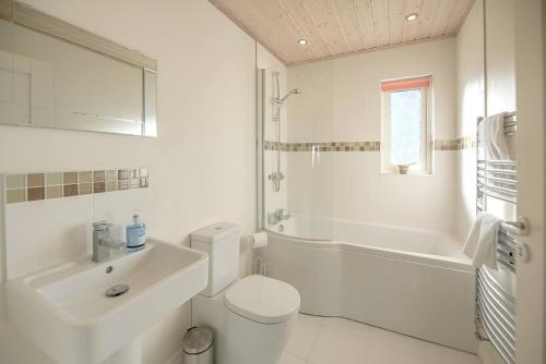 uma casa de banho branca com um lavatório e um WC em Stargaze em Great Yarmouth
