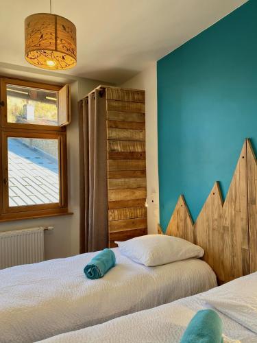 une chambre avec deux lits et un mur bleu dans l'établissement Tour Ramus- appartements, à Albertville