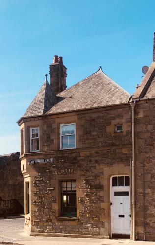 an old stone building with a white door at Castle Nook in Kelso