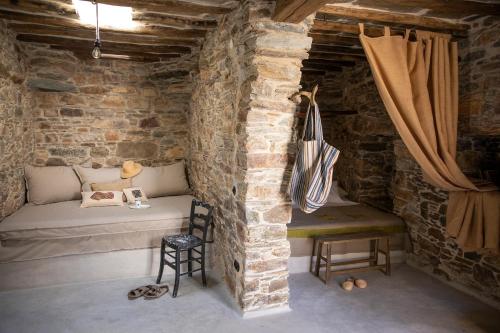 Habitación con 1 cama y 1 silla en una pared de ladrillo. en Onos Eco Living en Mési