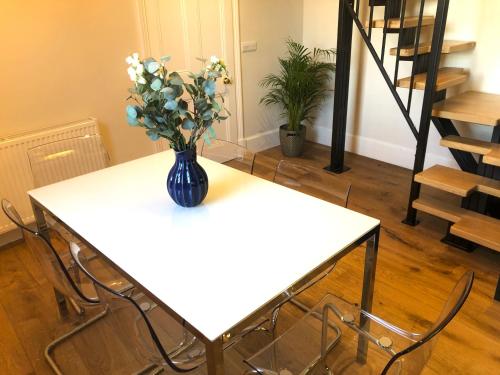 a white table with a vase of flowers on it at Castle Nook in Kelso