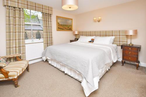 Un dormitorio con una gran cama blanca y una ventana en The Fountain Inn, en Leek