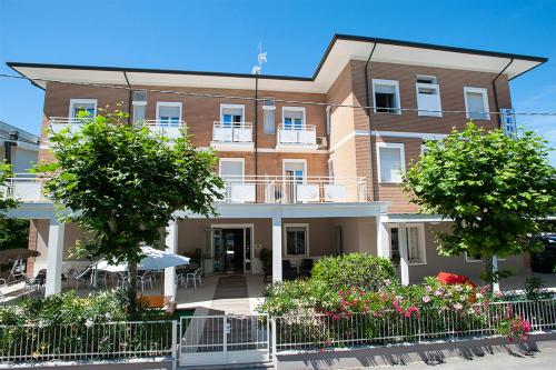 un gran edificio de ladrillo con árboles delante de él en B&B Hotel Serenità, en Bellaria-Igea Marina