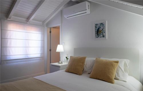 um quarto branco com uma cama branca e uma janela em Casas Peralta - Marialva em Arouca
