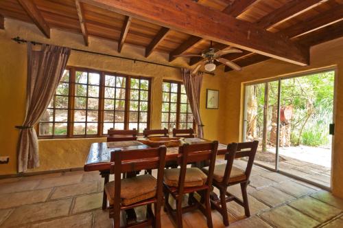 a dining room with a wooden table and chairs at Greenfire Hazyview Lodge in Hazyview