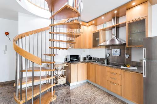 una cocina con armarios de madera y una escalera de caracol en Rent like home - Za Cieszynianką 5 en Zakopane