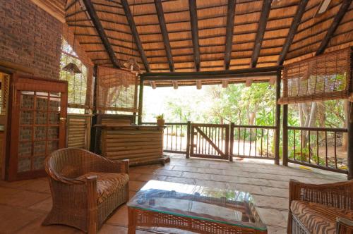 a screened in porch with a table and chairs at Greenfire Hazyview Lodge in Hazyview