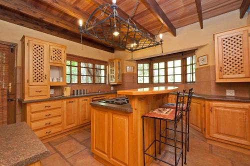 a large kitchen with wooden cabinets and a center island at Greenfire Hazyview Lodge in Hazyview