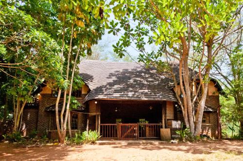 a house with a black roof and some trees at Greenfire Hazyview Lodge in Hazyview