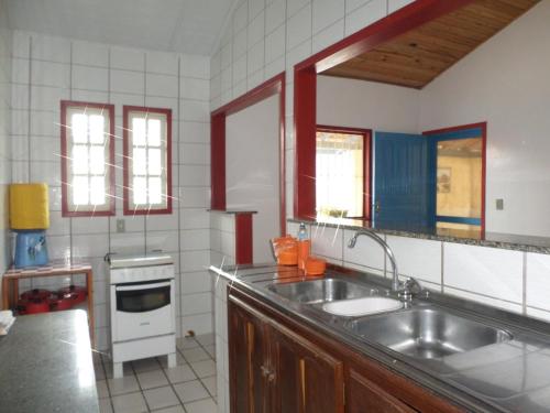 a kitchen with a sink and a stove at Casa Descanso dos Amigos in Prado