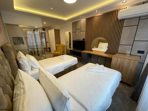 a hotel room with two beds and a television at Hotel & Restaurant Ponte Bianco in Vranje