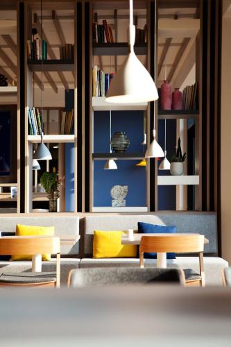 a living room with a couch and tables and shelves at Holiday Inn Express Munich - Olching by IHG in Olching