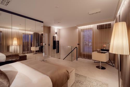 a bedroom with a bed and a desk and a chair at ONE Luxury Apartments in Rzeszów