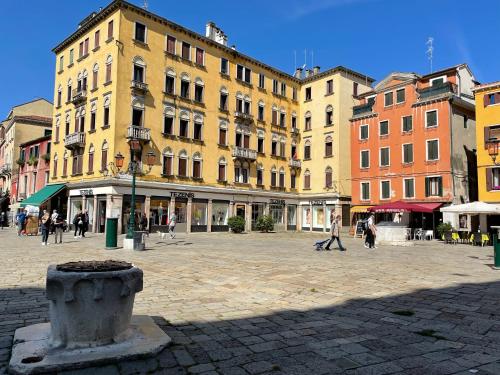 a group of buildings with people walking in a plaza at Hotel San Geremia in Venice