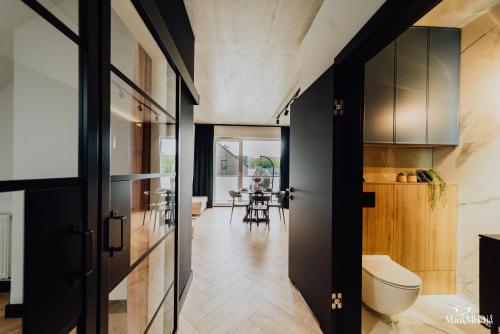 a hallway with black doors and a kitchen with a table at Apartament LUX 2 Cieplice in Jelenia Góra