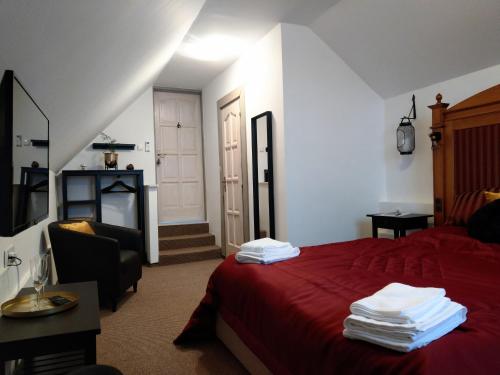a bedroom with a red bed with a red blanket at Klára-Háza Vendégház in Tiszadorogma