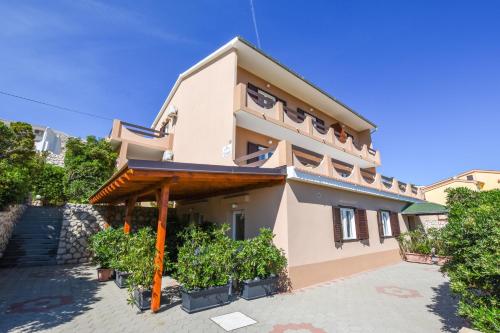 a house with a balcony and plants in front of it at APARTMANI MARIJA LJUBICA in Pag