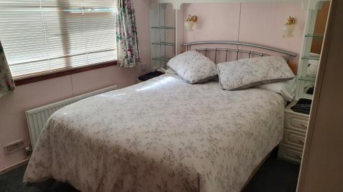 um quarto com uma cama com duas almofadas em Huntersfield Chalet em Faringdon