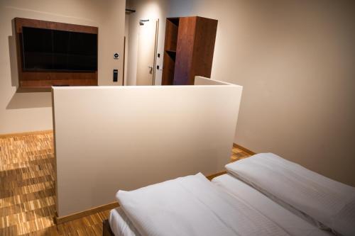 a white wall in a room with two beds at Cavallestro Deluxe in Kitzingen