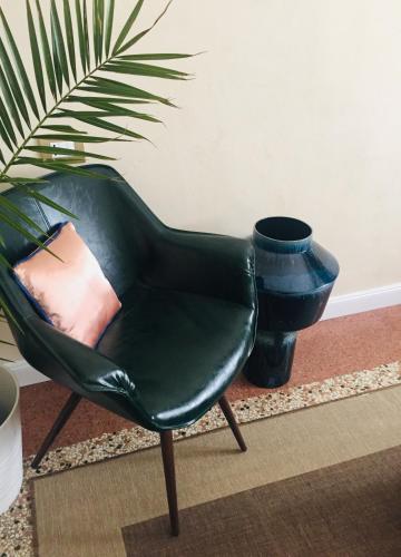 a green chair sitting next to a potted plant at Addler House Apt by Addler House Ospitality in Mestre