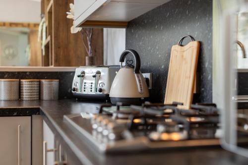 a kitchen counter with a tea kettle on the stove at Inside No 1 Retreat Carnforth in Carnforth