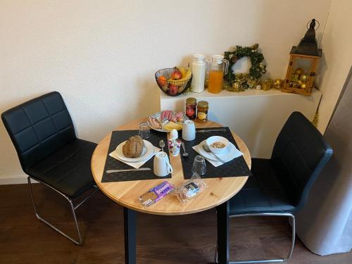 een kleine tafel met twee stoelen en eten erop bij B&B by the C in Vlissingen