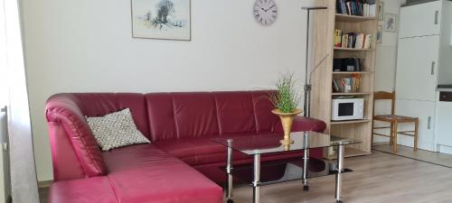 a red couch in a living room with a table at Waldoase-Appartement im Tannenhof in Haidmühle