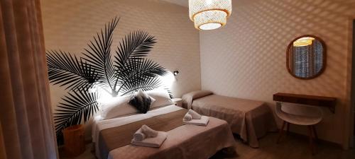 una habitación de hotel con 2 camas y una palmera en B&B Hotel Serenità, en Bellaria-Igea Marina
