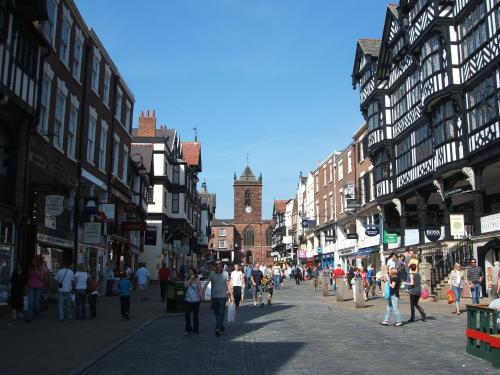 a group of people walking down a city street at The Foresters Arms in Tarporley
