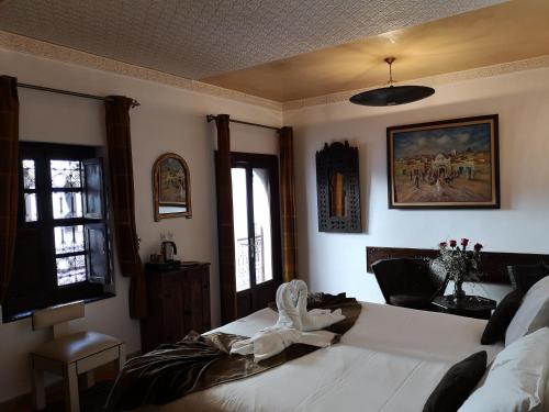 a bedroom with a white bed in a room with windows at Riad Charme d'Orient Adults Only in Marrakech
