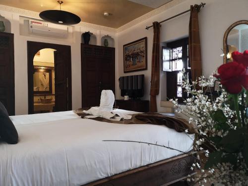 a bedroom with a large bed with white sheets at Riad Charme d'Orient Adults Only in Marrakech