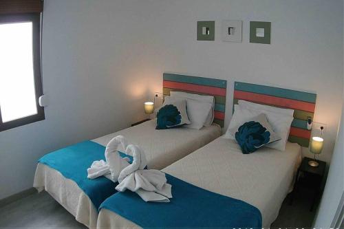 two beds in a hotel room with towels on them at La Gaviota apartment, in the heart of the port in Jávea