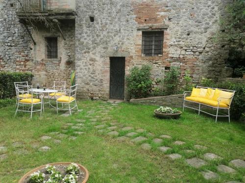 a patio with chairs and a table in a yard at Residenza Le Peonie in Todi