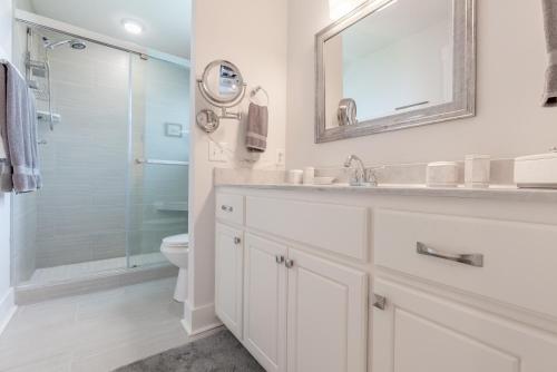een witte badkamer met een wastafel en een douche bij Three Palms Tree Home in Panama City Beach
