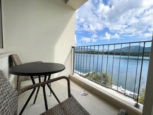 a balcony with a table and a view of the water at Apartments Maestral in Tivat