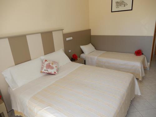 a hotel room with two beds with red roses at Hotel San Giorgio in Vasto
