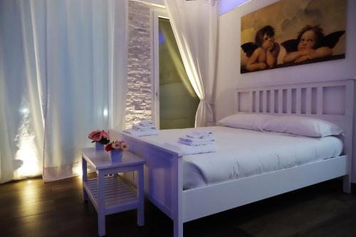Schlafzimmer mit einem Bett mit einem Tisch und einem Spiegel in der Unterkunft La Dolce Notte in Matera