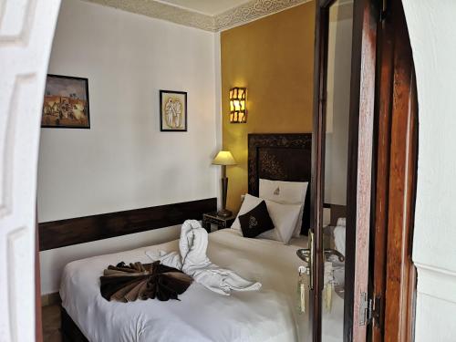 a bedroom with two beds with white sheets at Riad Charme d'Orient Adults Only in Marrakech