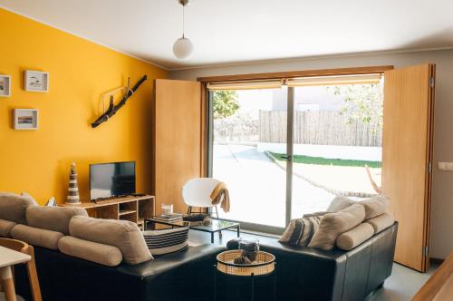 a living room with a couch and a television at Casa da Figueira in Moledo