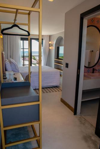 a bedroom with a bed and a ladder to a bunk bed at Exótica Boutique Hotel in Pipa