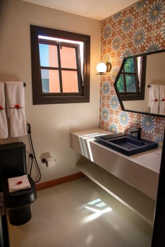 a bathroom with a sink and a mirror at Exótica Boutique Hotel in Pipa