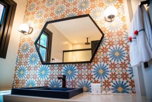 a bathroom with a sink and a mirror on a wall at Exótica Boutique Hotel in Pipa